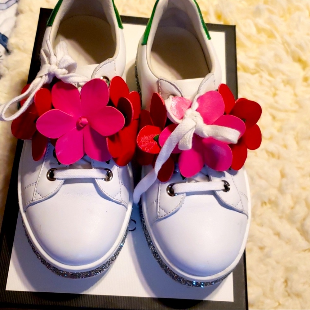 Cute girl Gucci sneakers with floral design to cover laces.